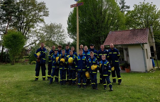 THW-Jugend vor aufgestelltem Maibaum mit Kranz und KMS 2024 Schild
