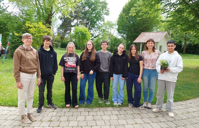 Schülerinnen und Schüler mit Mitarbeitenden im Garten des Konrad-Manopp-Stifts