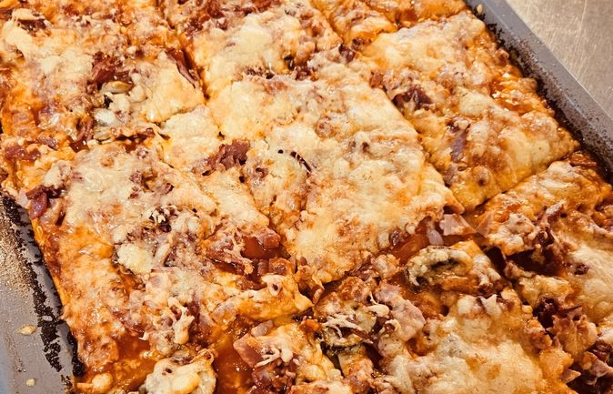 Blechpizza mit geschmolzenem Käse, Pilzen und Schinken
