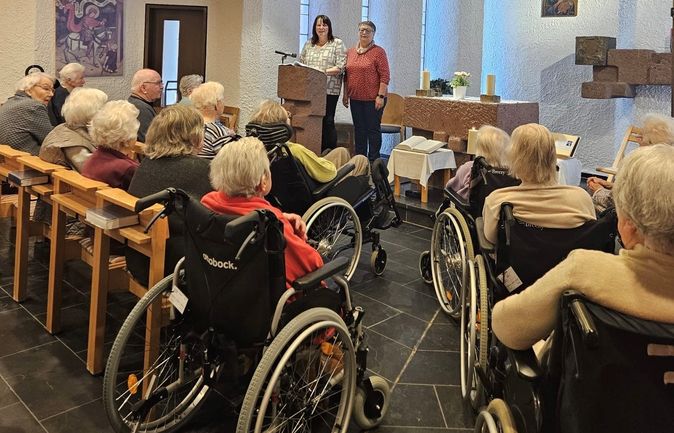 Ältere Menschen beim Karfreitagsgottesdienst in der Kapelle zwei Frauen am Ambo