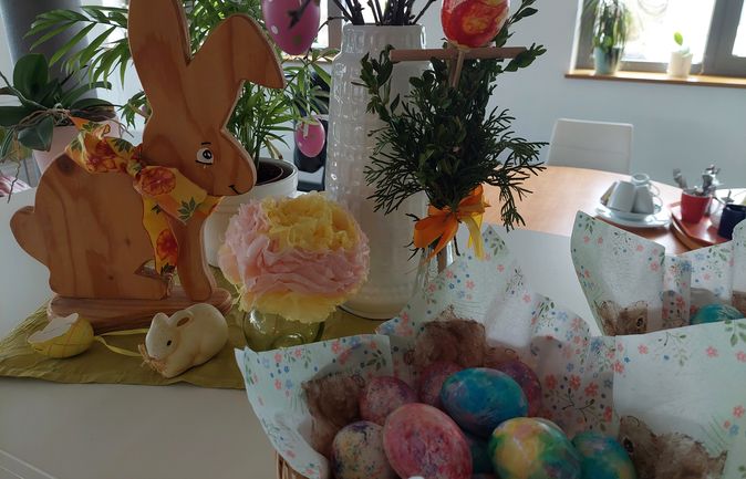 Bunte Ostereier, ein Osterstrauß und ein Holzosterhase
