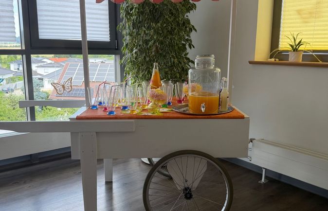 Servierwagen mit Glaskaraffe und alkoholfreien Cocktails mit Erdbeere