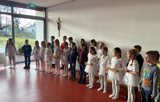 Kinder stehen in Reihe mit Triangel und Xylophon im Konrad-Manopp-Stift