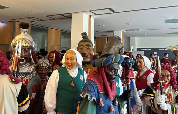 Gruppe verkleideter Narren mit traditionellen Holzmasken beim Fasnetsfreitag