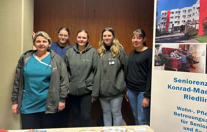 Fünf Mitarbeiterinnen an Infostand beim Berufsorientierungstag